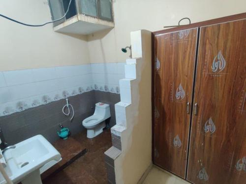 a bathroom with a toilet and a sink at Second Home Hotel in Multan