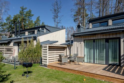 a house with a deck and a patio at Sunset House in Palanga