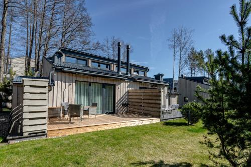 a house with a wooden deck in a yard at Sunset House in Palanga