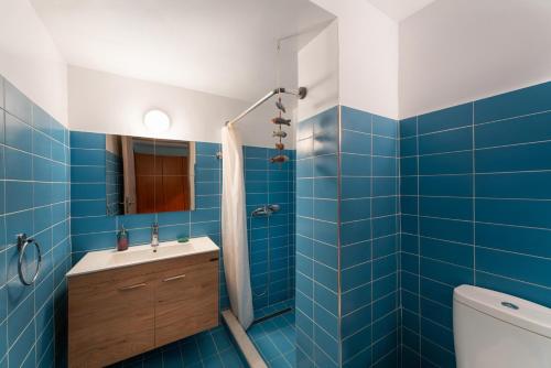 a blue tiled bathroom with a shower and a sink at Folitsa happy central home in Rhodes Town