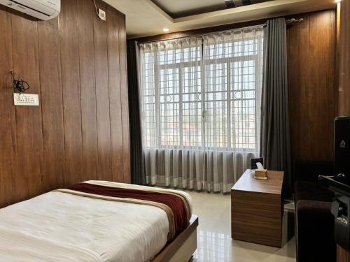 a bedroom with a bed and a large window at Shahi Land Hotel Pvt Ltd in Butwāl