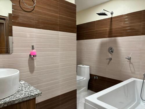 a bathroom with a white sink and a toilet at Shahi Land Hotel Pvt Ltd in Butwāl