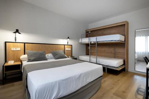 ein Schlafzimmer mit zwei Betten und einem Etagenbett in der Unterkunft Hotel Marfany in Andorra la Vella
