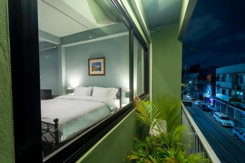a bedroom with a bed on a balcony at Baan Batra Heritage Suite in Bangkok
