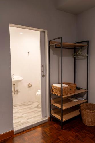 a bathroom with a shower and a sink and a toilet at Baan Batra Heritage Suite in Bangkok
