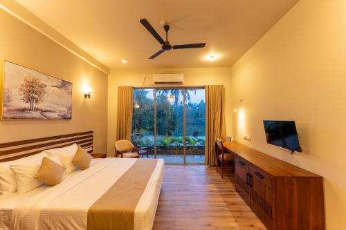 a bedroom with a bed and a tv and a window at Aqualuna Weligama in Weligama