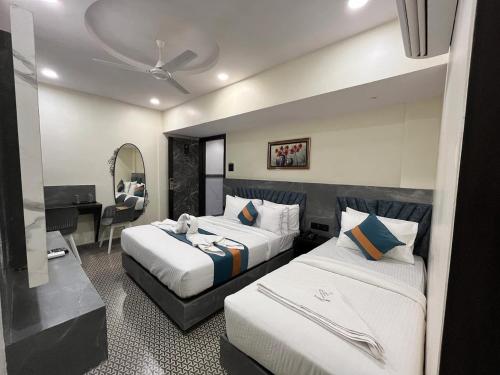 a hotel room with two beds and a desk at DIAMOND HOTEL in Mumbai