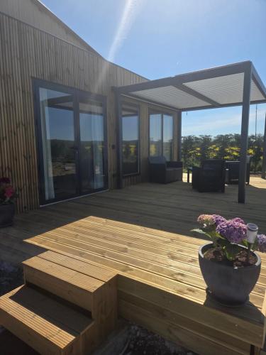 a wooden deck with a pot of flowers on a building at La roseraie in Abbécourt