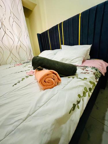 a bed with green and pink sheets and pillows at The perfect Hideout in Nairobi