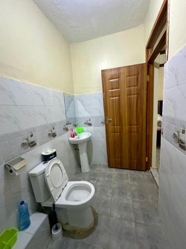 a bathroom with a toilet and a sink at The perfect Hideout in Nairobi