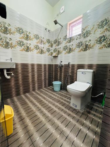 a bathroom with a toilet and a sink at Babuloos Homestay in Varkala