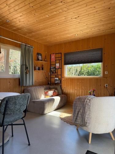 a living room with a couch and a table and a window at vakantiehuisje Zusje met eigen sauna in Bruchterveld