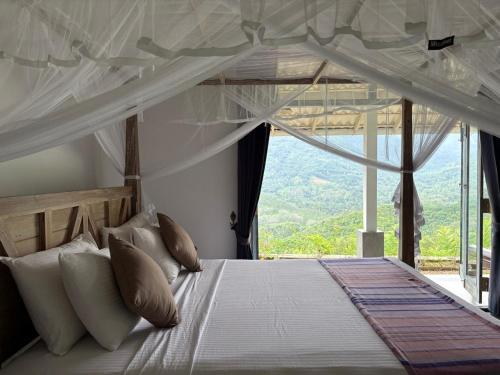 a bedroom with a bed with a large window at Leaf Olu Ella in Yatiyantota
