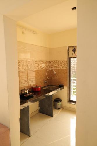 a kitchen with a stove and a sink in it at FabHotel Aqua Pearl Inn in Navi Mumbai