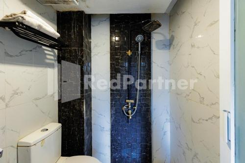a bathroom with a shower with a toilet in it at Tree Homestay Mitra RedDoorz in Kasri