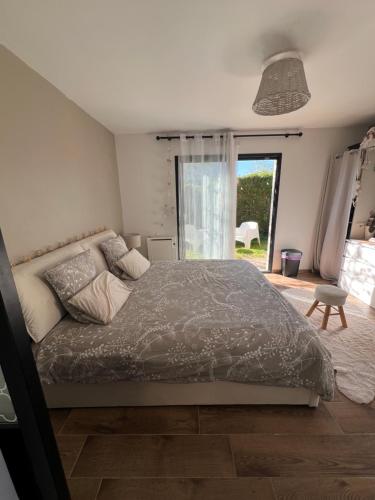 a bedroom with a bed and a large window at Quiniere - 25 m2 indépendant avec piscine - Wifi in Blois