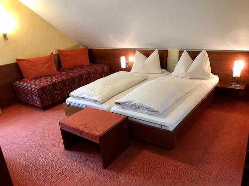 a bedroom with a large bed and a couch at Gasthaus zum Hirsch Hotel - Restaurant in Weier