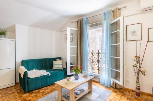 a living room with a green couch and a table at Apartman Ana Lotre in Vela Luka