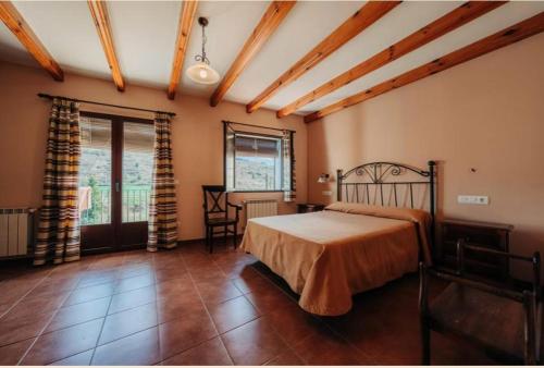 a bedroom with a bed and a table and a window at Cases Tonet 3 in Forcall