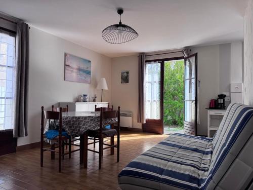 a living room with a table and chairs and a bed at Maisonnette au centre de St Pierre in Saint-Pierre-dʼOléron