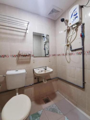 a bathroom with a toilet and a sink at My Seven Day Inn in Masai