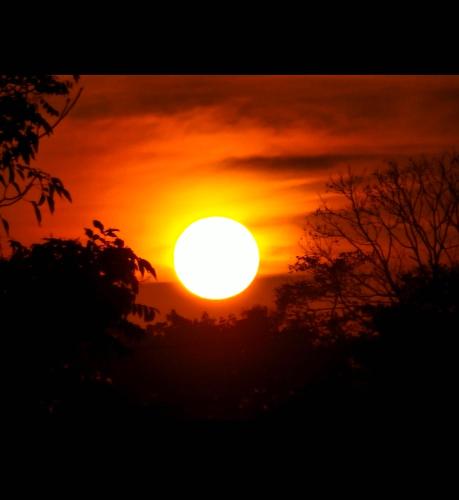 a sunset with the sun in the sky at Hostel Samara in Sámara