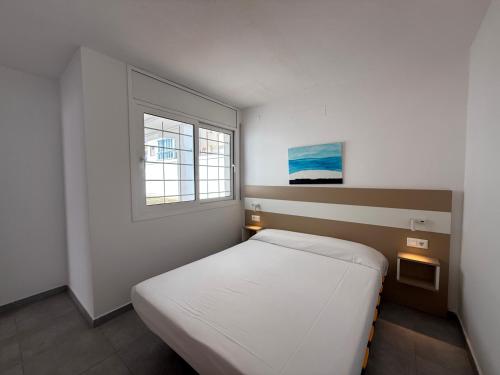 a small bedroom with a bed and a window at Agi Las Acacias in Roses