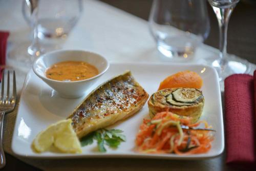 a plate of food with fish and a bowl of soup at Best Western Le Pont d'Or in Figeac
