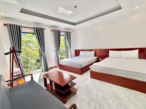 a hotel room with two beds and a window at Khách sạn Vân Nhi 2 in Bạc Liêu