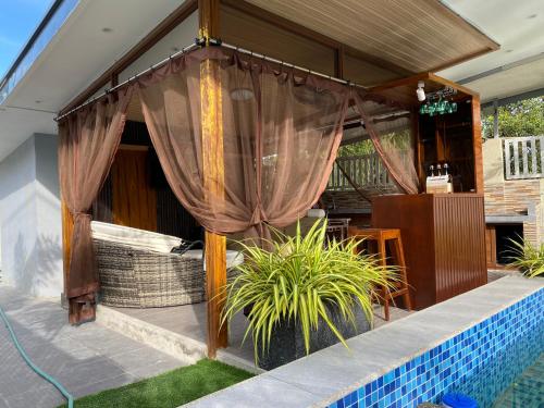 a patio with a curtain and a pool at Casa Sandrine Resort in Malolos
