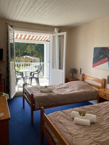 two beds in a room with a balcony at Les Chênes verts in Saint-Savinien