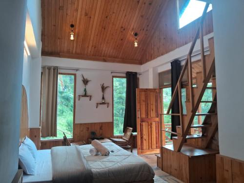a bedroom with a large bed and wooden ceilings at Bhindeshi Tara Stays Jibhi Mihar in Jibhi