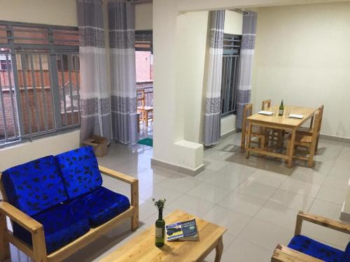 a living room with a blue couch and a table at Bella Famiglia in Ruhengeri
