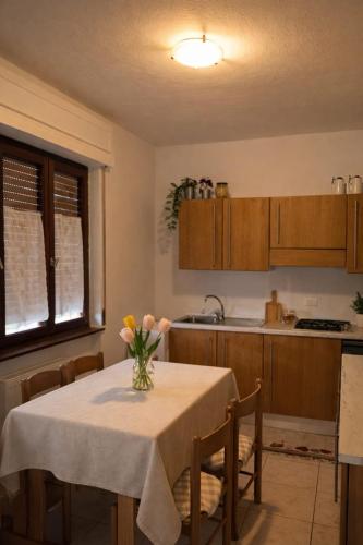 a kitchen with a table with a vase of flowers on it at Noi - Casa vacanza in Attimis