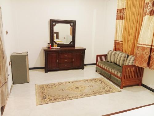 a living room with a couch and a mirror at Holiday Apartment Ragama in Kurukulawa