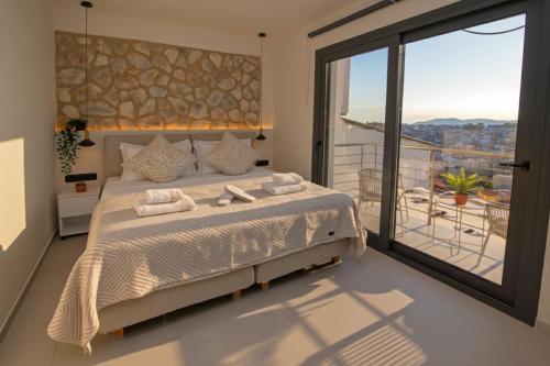 a bedroom with a large bed and a balcony at kallos of Skiathos in Skiathos