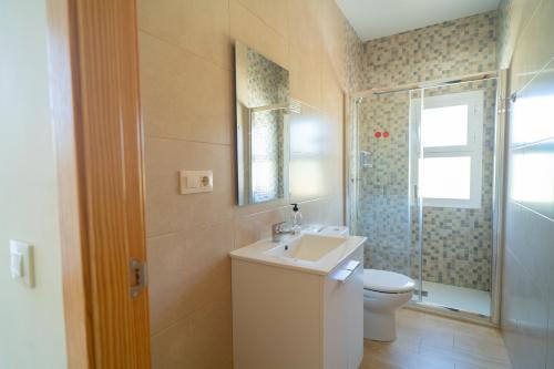 a bathroom with a sink and a toilet and a shower at Piso La Buganvilla in Bailén