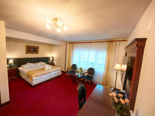 a hotel room with a bed and a large window at Hotel Select in Băile Olăneşti