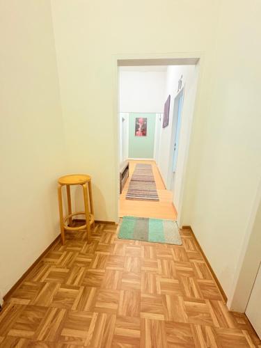 a hallway with a wooden floor and a chair at Beenie 16 in Linz