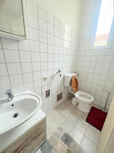 a white bathroom with a sink and a toilet at Beenie 16 in Linz