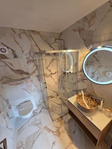 a bathroom with a marble wall and a mirror at Hotel Select in Băile Olăneşti