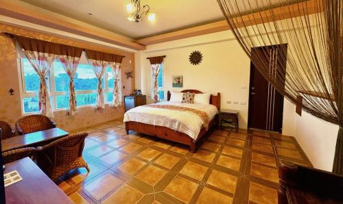 a bedroom with a bed and a table and chairs at Cloudenjoy B&B in Hualien City