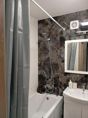 a bathroom with a shower curtain and a sink at Dolce Vita in Ternopil