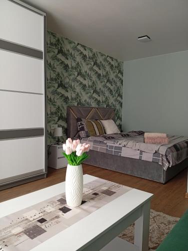 a bedroom with a bed and a vase with flowers on a table at Dolce Vita in Ternopil