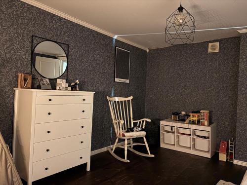 a bedroom with a dresser and a mirror and a chair at Hus Orsa in Orsa