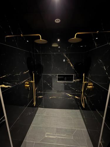 a dark room with black marble walls and lights at Hollywood Spa Jacuzzi - Cinéma in Château-Thierry