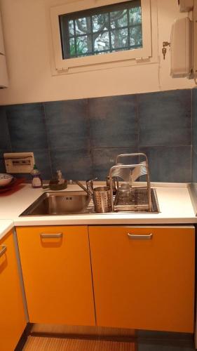 a kitchen with orange cabinets and a sink at la Baracca in Genoa