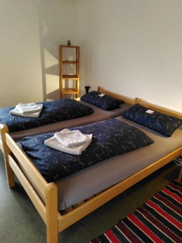 zwei Betten in einem Zimmer mit Handtüchern darauf in der Unterkunft Zimmer 13 in Gomadingen