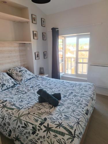 a bedroom with a bed with a blue and white blanket at Appartement cosy calme centre Issoire Belle vue sur le massif du Sancy et le Livradois-Forez WiFi in Issoire