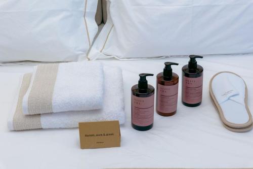 a group of three bottles on a bed with towels at kallos of Skiathos in Skiathos